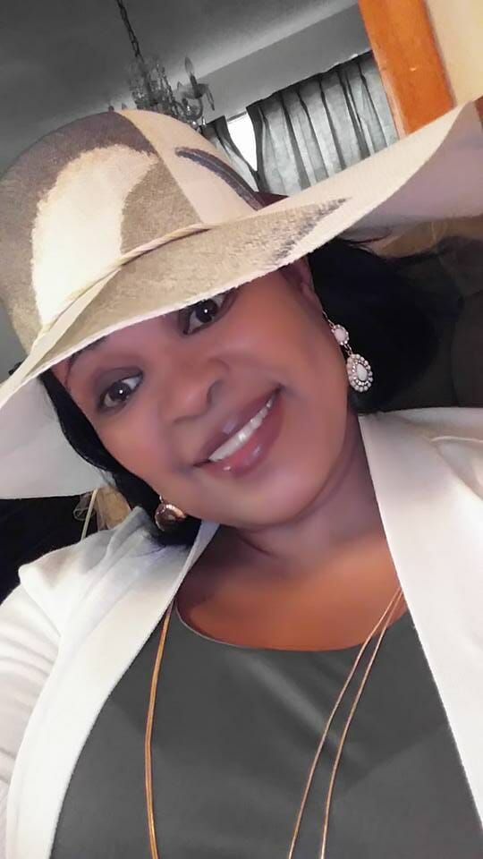 Ashro Woman of the Week, Janice, a smiling African-American woman in a cream hat, white jacket and green top.