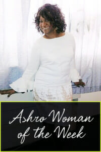 Ashro Woman of the Week MARY, an African-American woman wearing a white dress, posed by a curtained window.
