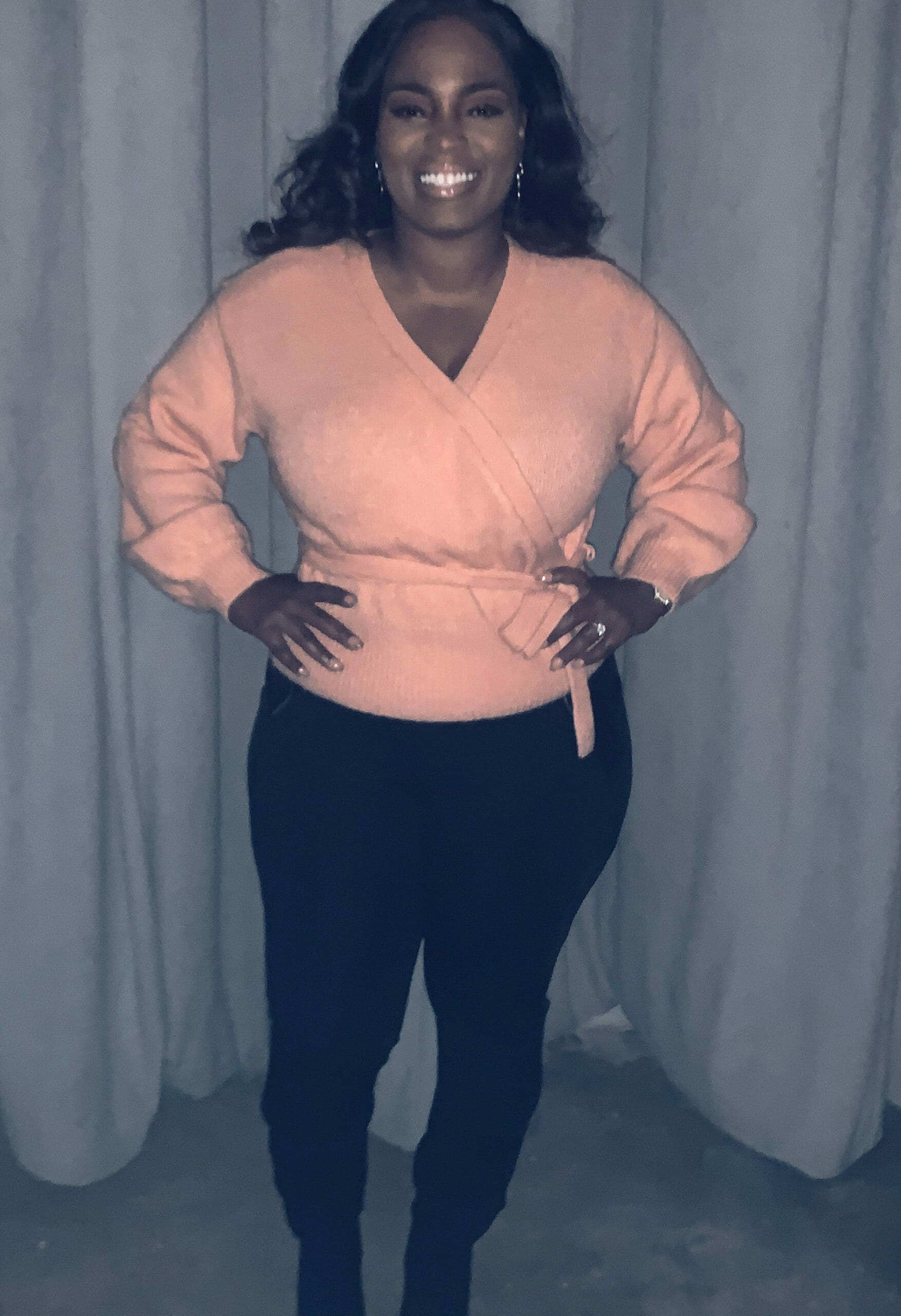 Ashro Woman of the Week ANGELA, a smiling African-American woman wearing a pink top and black slacks.