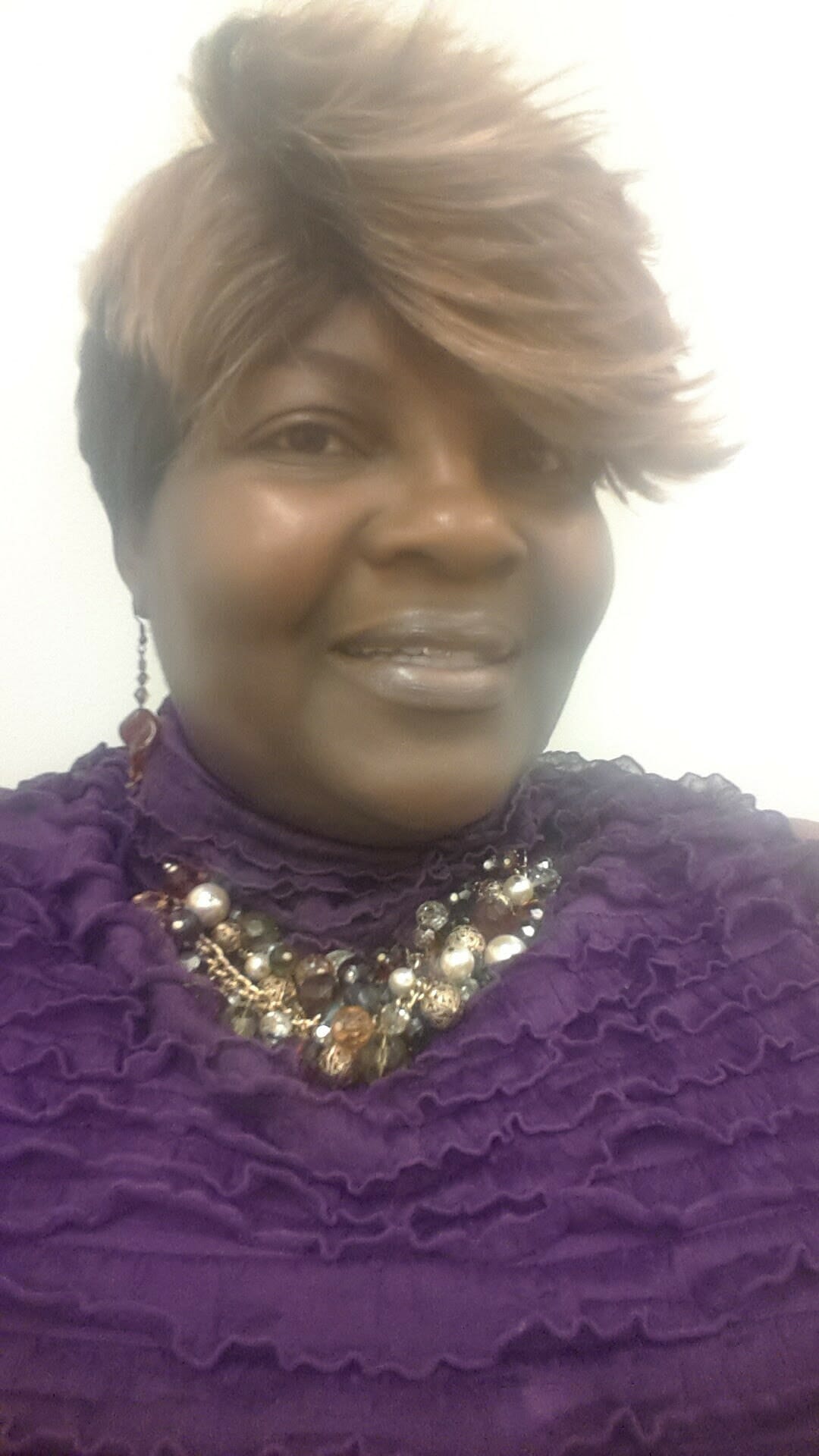 Ashro Woman of the Week Brenda, a smiling African-American woman wearing a purple dress
