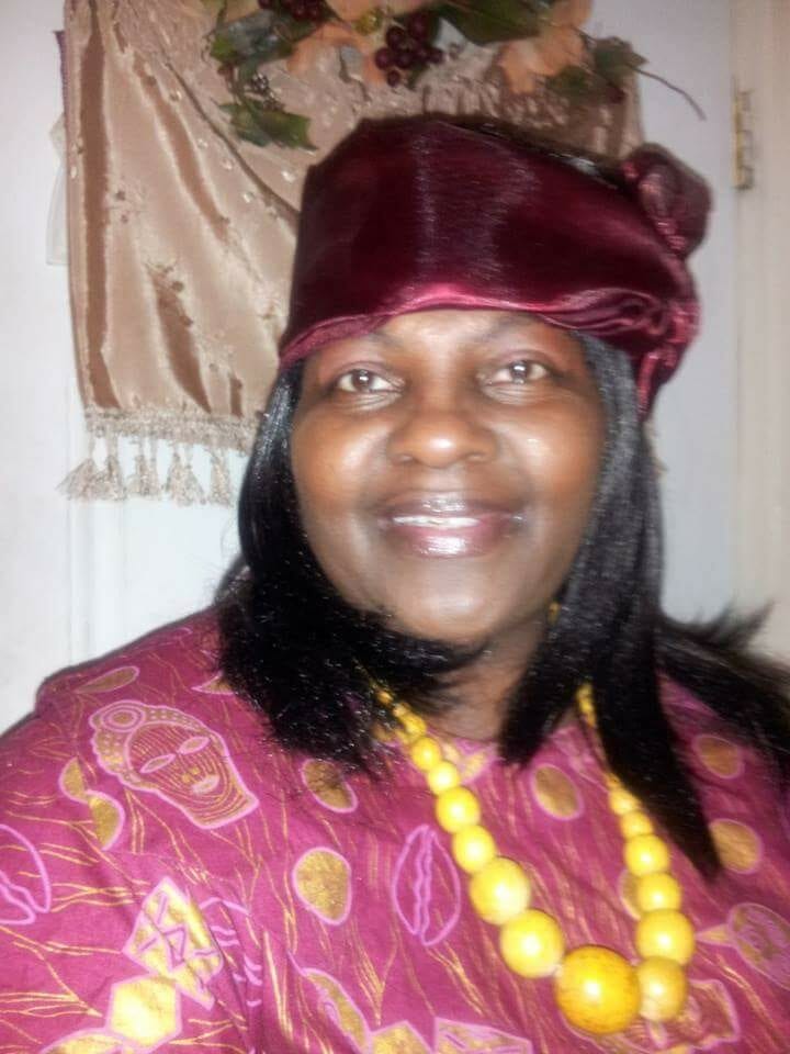 Ashro Woman of the Week Brenda, a smiling African-American woman wearing a red floral pattern dress and a red headwrap