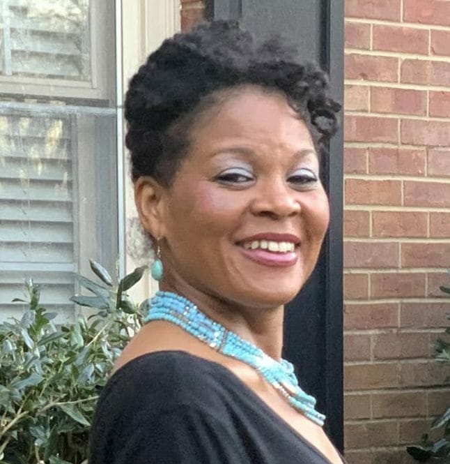 black woman in a black dress with a teal necklace