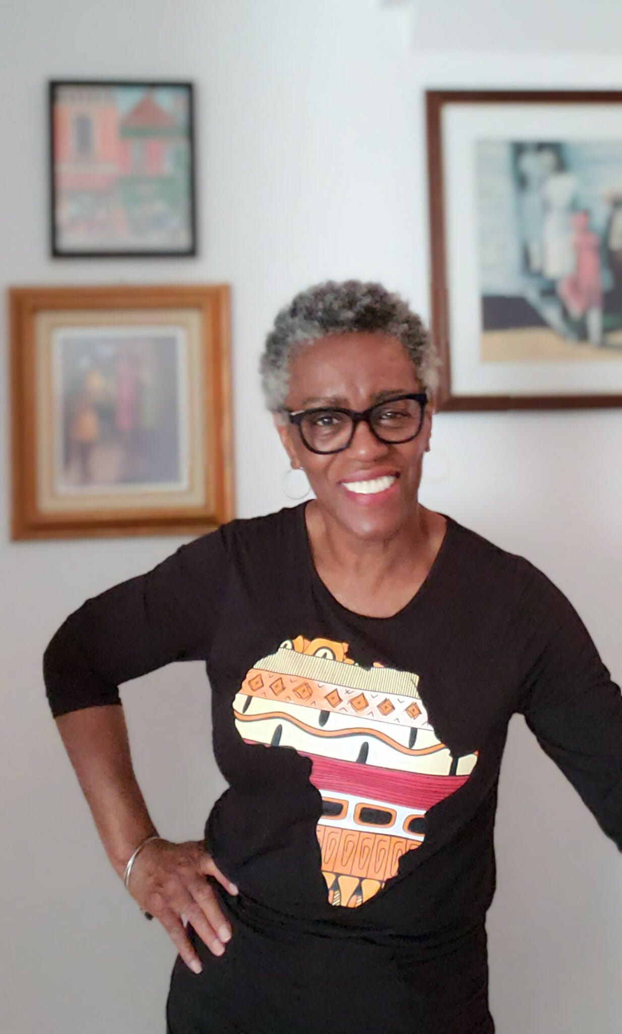 black woman smiling wearing a black shirt with africa image in the front