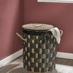 Hamper on natural rug with rust wall and vases