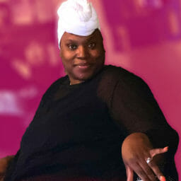 Black woman wearing headwrap & Ashro fashions