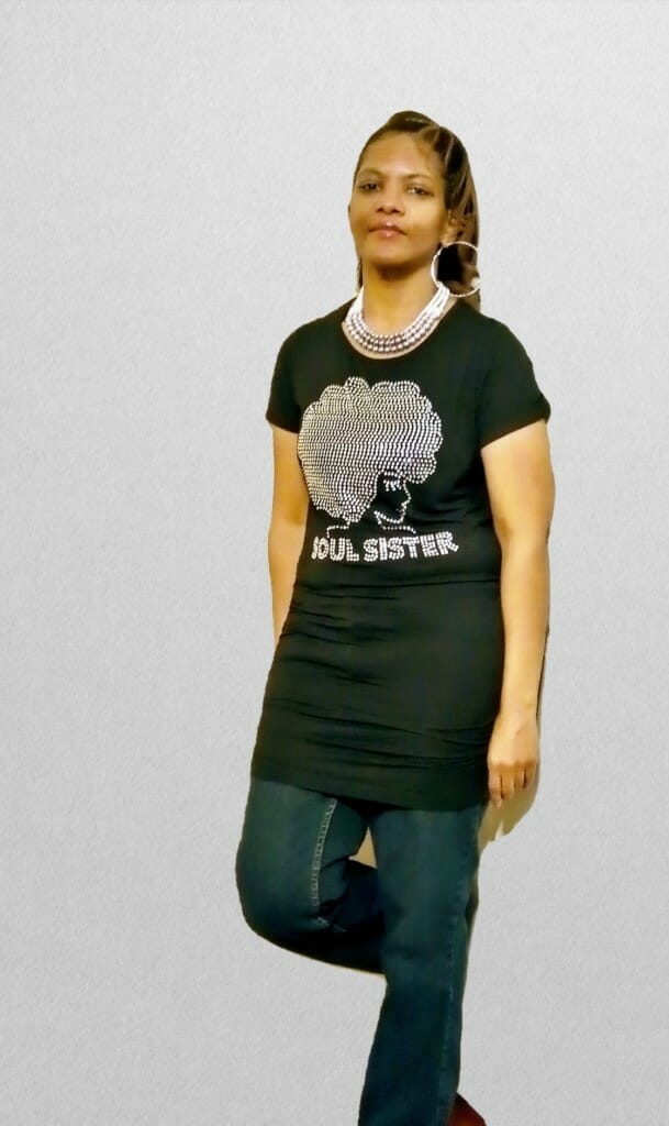 Kimberly Fisher (Ashro customer) posing with one leg up leaning on wall wearing Ashro Soul Sister shirt.
