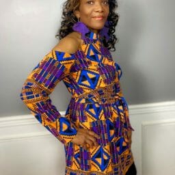 Kimberly (Ashro customer) posing in orange and blue afrocentric pattern top.