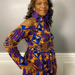 Kimberly (Ashro customer) posing in orange and blue afrocentric pattern top.