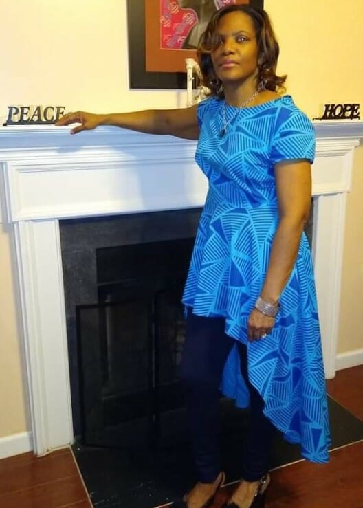 Kimberly F posing by fireplace with blue top