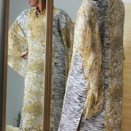 Ashro Customer Kiauna posing in front of mirror with printed head wrap and dress