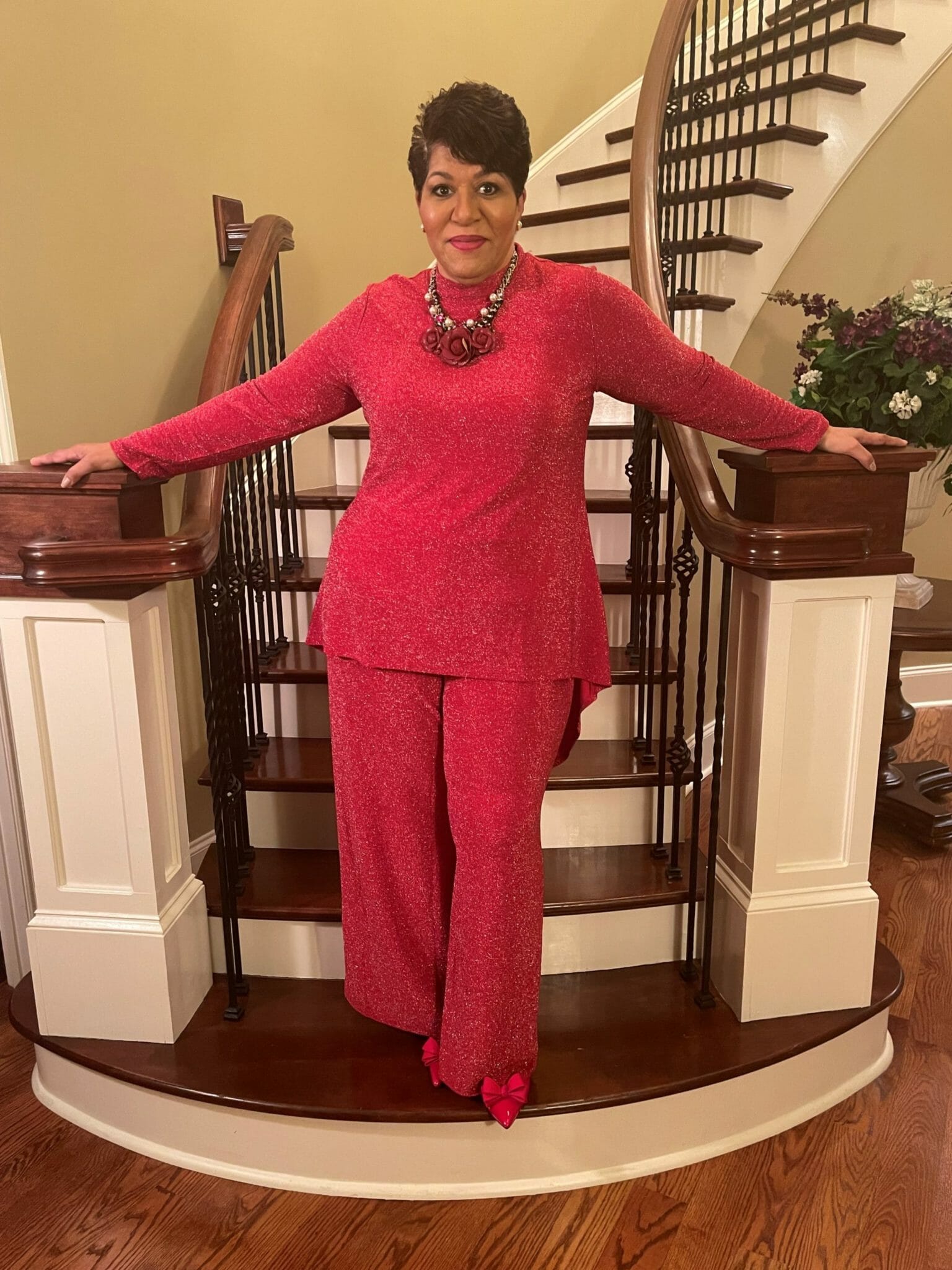 Ashro customer wearing a sparkly red pant suit posing on a stair well