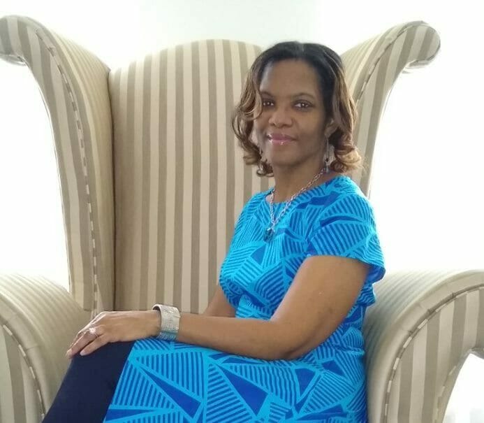Ashro customer wearing high low blue top sitting in a chair