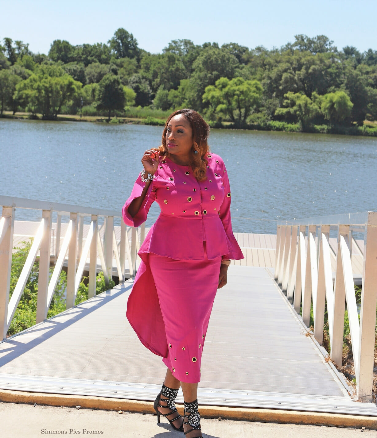 Vertical Image of Woman posing at a water front in a two piece pink suit set