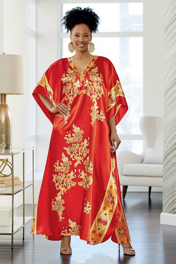 African American woman wearing Blare Caftan in red, gold and white with gold earrings.