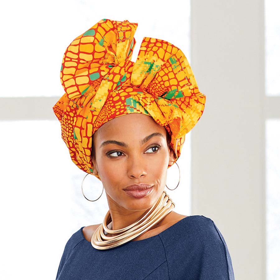 African American woman wearing yellow, orange and green Asia Headwrap with matching Asia Denim Ankara Dress and gold hoop earrings and necklace.