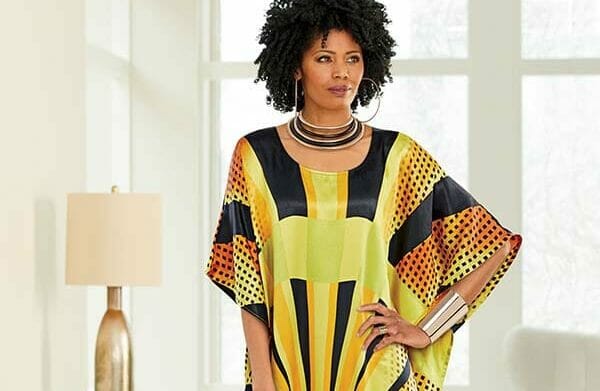African American woman in yellow, orange and black caftan.