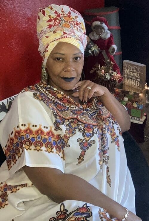 Image of Woman wearing multicolor caftan with matching head wrap.
