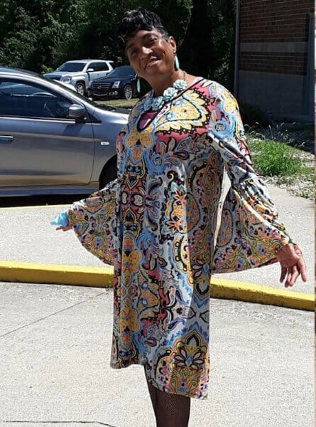 Black woman in a patterned caftan.