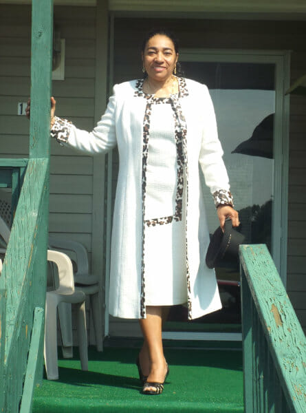 woman standing on porch steps in white outfit