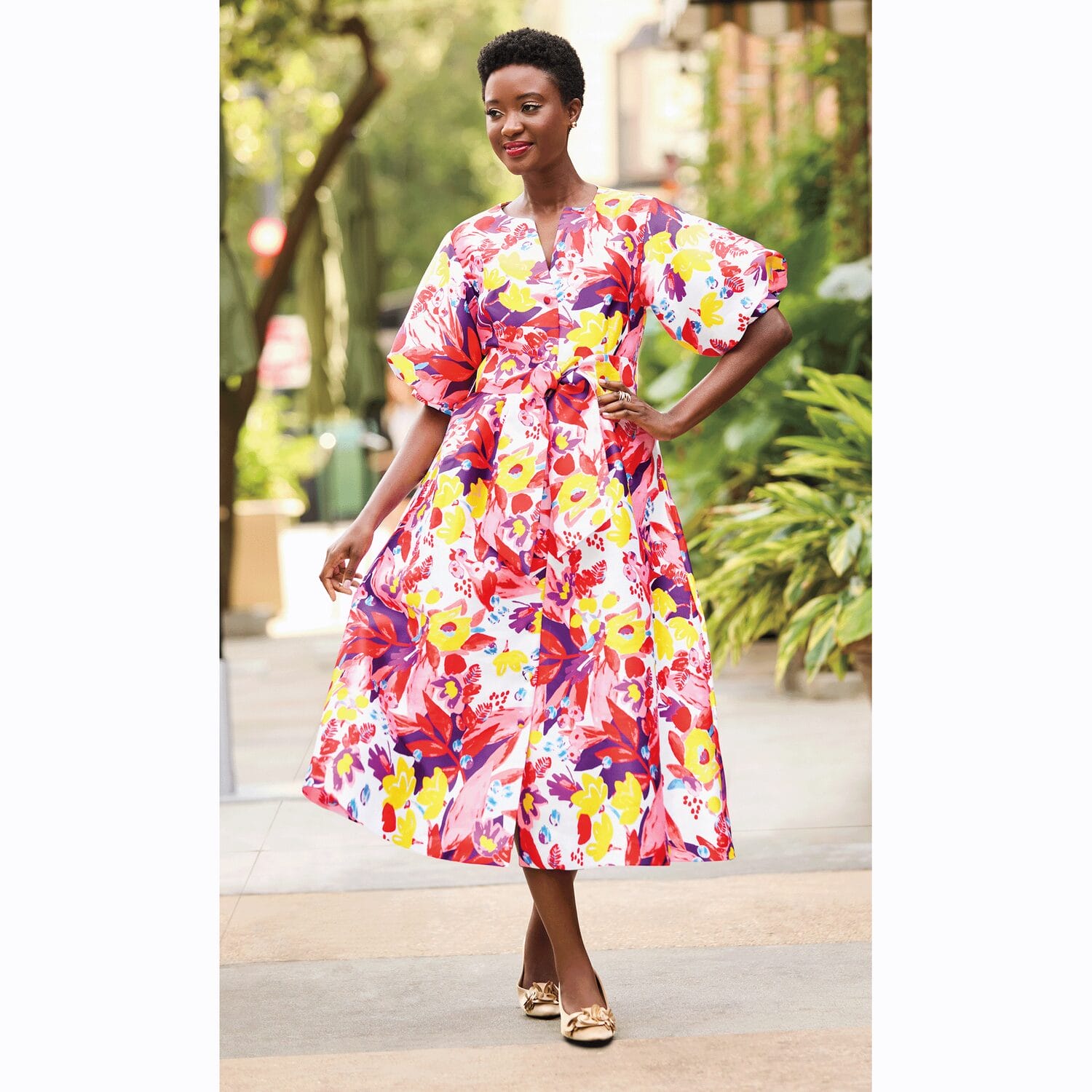 Black model wearing a colorful fit and flare dress.